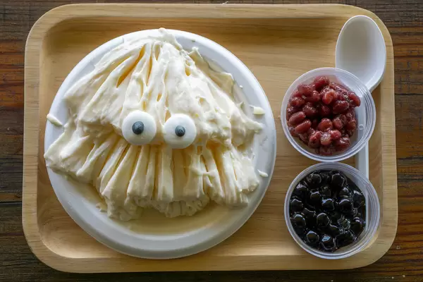 Top View Food Photo of Vanilla Ice Cream with Candy Eyes, Beans and Jelly on a Wooden Tray