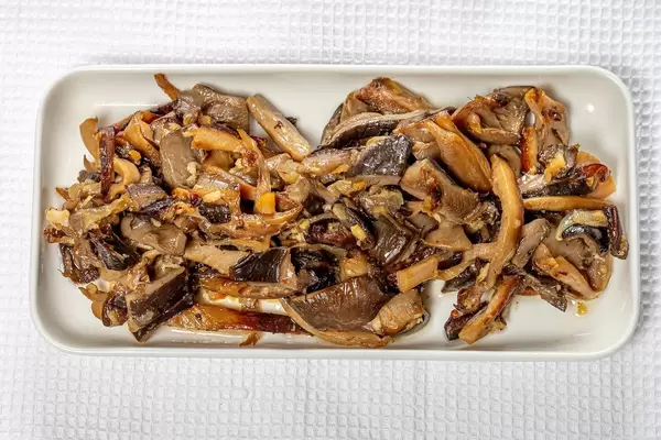 Top view fried oyster mushrooms with onions on a white kitchen towel (Flip 2019)