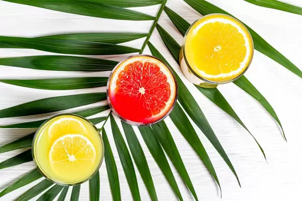 Top-view Gläser mit Orangen, Zitronen und Grapefruit Saft auf einem grünen Blatt
