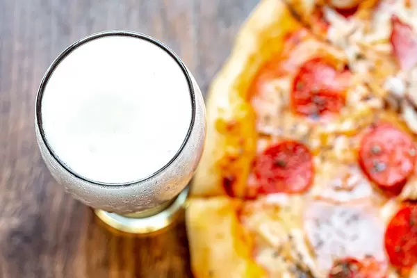 Top view glass of light beer and pizza on wooden background (Flip 2019) (Flip 2019)