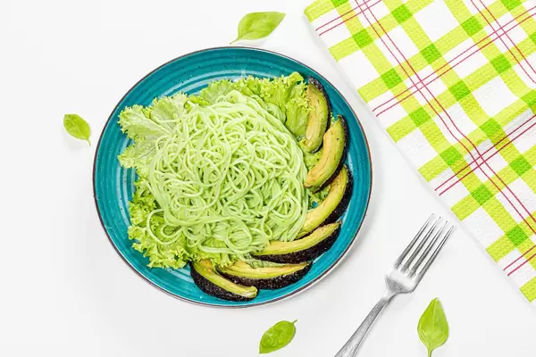 Top view green spaghetti with avocado slices, lettuce and basil (Flip 2019)