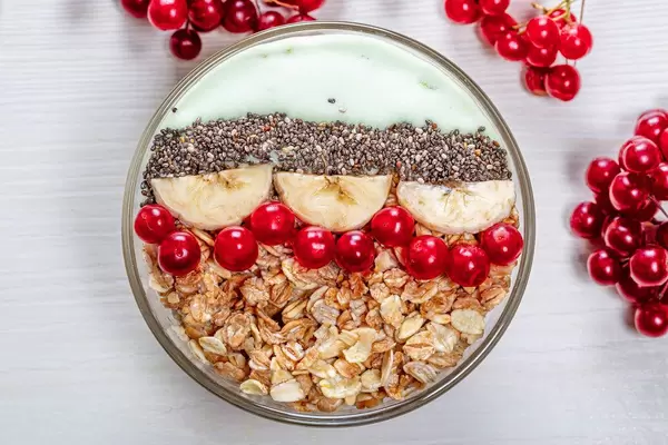 Top-view Haferflocken mit Chia Samen, Viburnum Beeren und Bananen Scheiben