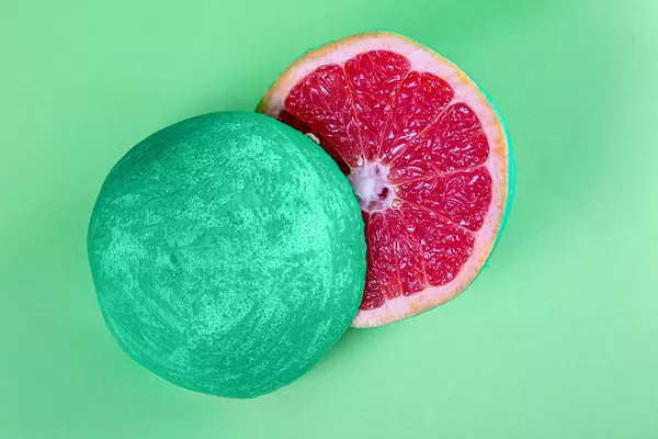 Top view, halved grapefruit with green peel on green background