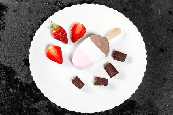 Top view ice cream with chocolate cubes and strawberries