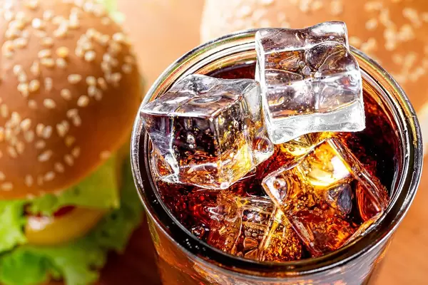 Top view ice cubes in a glass with a drink and burgers