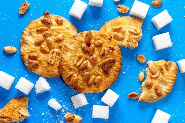 Top-view Kekse mit Erdnüssen und Zuckerwürfel auf blauem Hintergrund