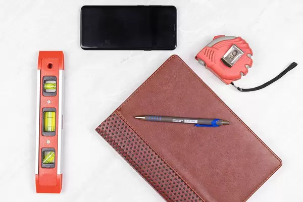 Top view Level Measure Tape Mobile phone Pencil and Paper Notebook