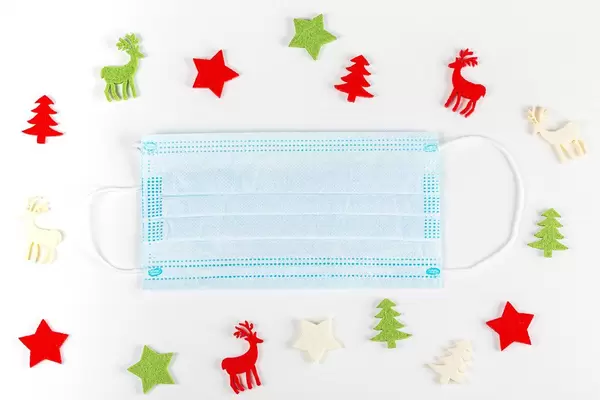 Top view, medical mask with christmas decor on white background