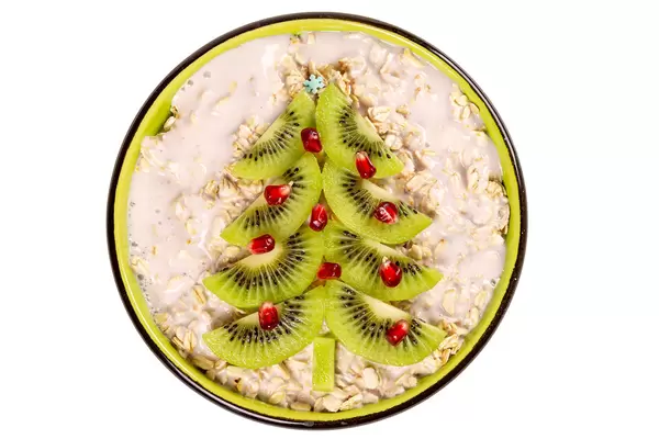 Top view, oatmeal decorated christmas tree made from kiwi slices