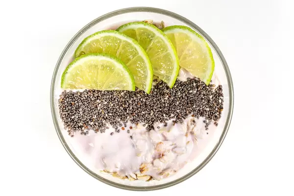 Top view, oatmeal with chia seeds and lime slices on a white background
