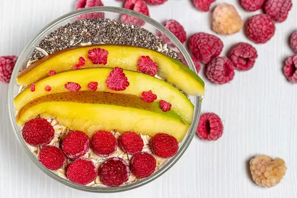 Top view oatmeal with mango slices, raspberries and Chia seeds (Flip 2019)