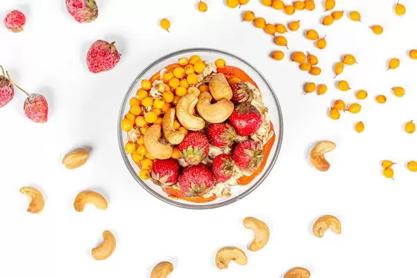 Top view , oatmeal with strawberries, sea buckthorn berries and cashew nuts (Flip 2020)