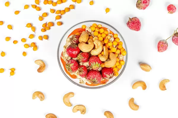 Top view , oatmeal with strawberries, sea buckthorn berries and cashew nuts