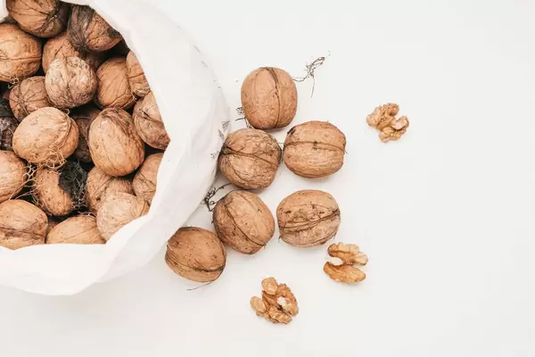 Top view of a bag of walnuts on white background