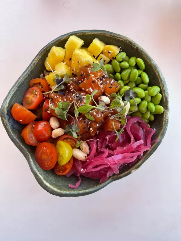 Top view of a bowl of healthy food on a white background: fruit, veggie, beans and herbs mix on Majorca