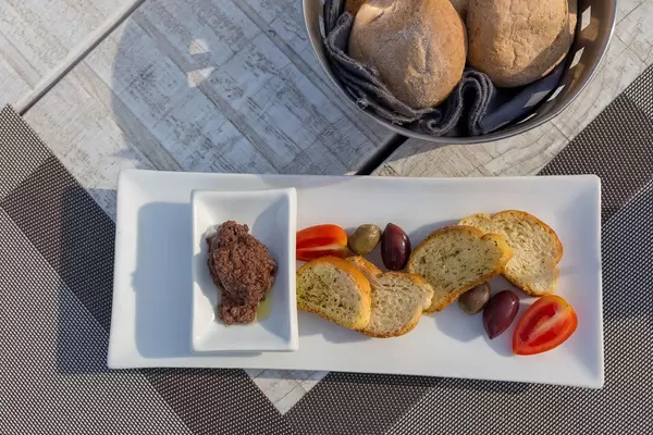 Top view of a Greek starter: black olives, cherry tomatoes and minced olives in olive oil