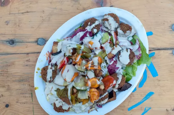 Top view of a hummus plate with falafel and deep fired veggies