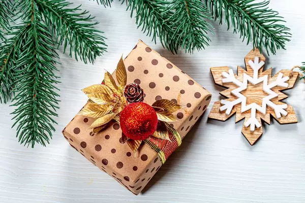 Top view of beautiful gift box and christmas tree branches on a white wooden background (Flip 2019)