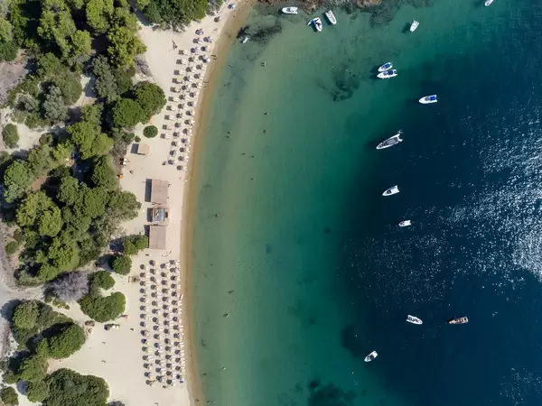 Top view of boats in the crystal clear waters of Tsougria, fine sand beach on the islet near Skiathos