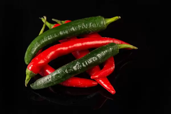 Top view of Chilli Hot Peppers above black background (Flip 2019)