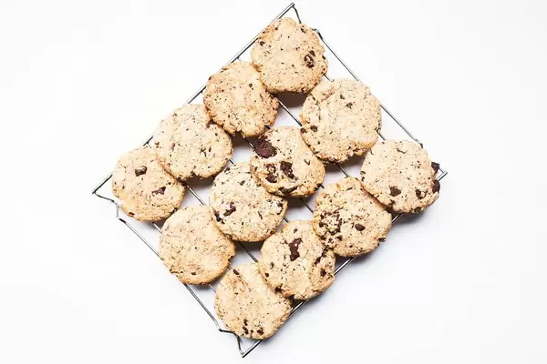 Top view of chocolate chip cookies on cooling rack i=on white background
