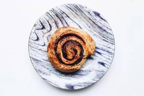 Top view of cinnamon roll in a colorful plate. White background