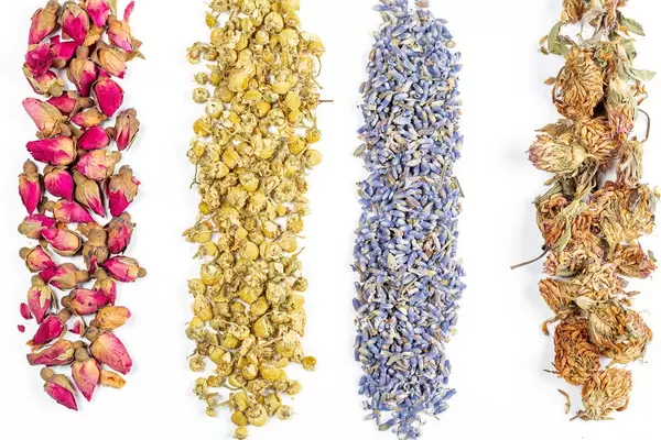 Top view of dried hibiscus, chamomile, lavender and stables flowers on a white background