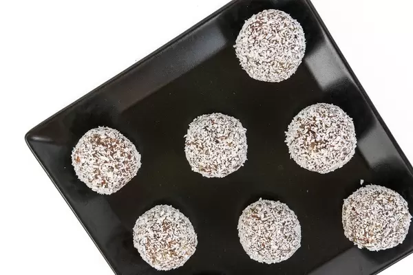 Top view of Energy Balls with Almonds Walnuts and Coconut on the black plate
