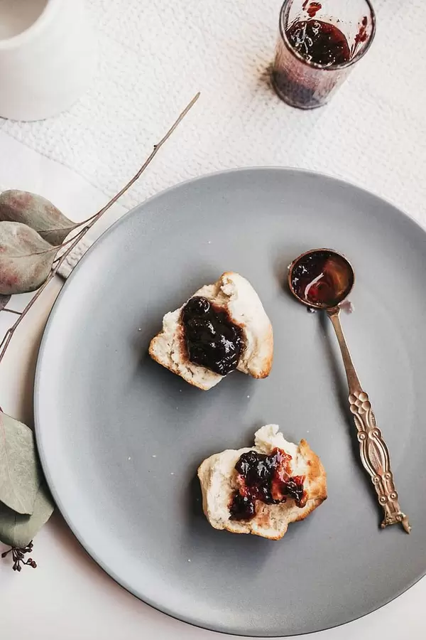 Top view of english brunch- homemade scones with jam on grey plate