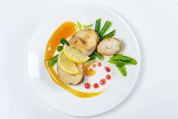 Top view of fish with asparagus, lemon and mango sauce