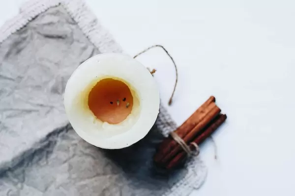 Top view of flat lay with candle and cinnamon sticks.