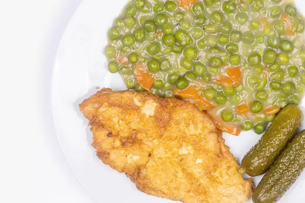 Top view of Fried Chicken breasts with cooked Green Peas