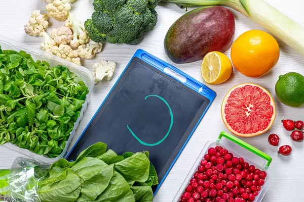 Top view of fruits, vegetables, herbs and berries on a white wooden background. Vitamin C-rich foods concept (Flip 2019)