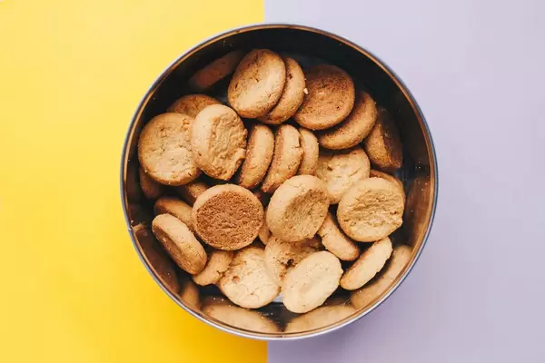 Top view of ginger cookies in a box. Yellow and purple background