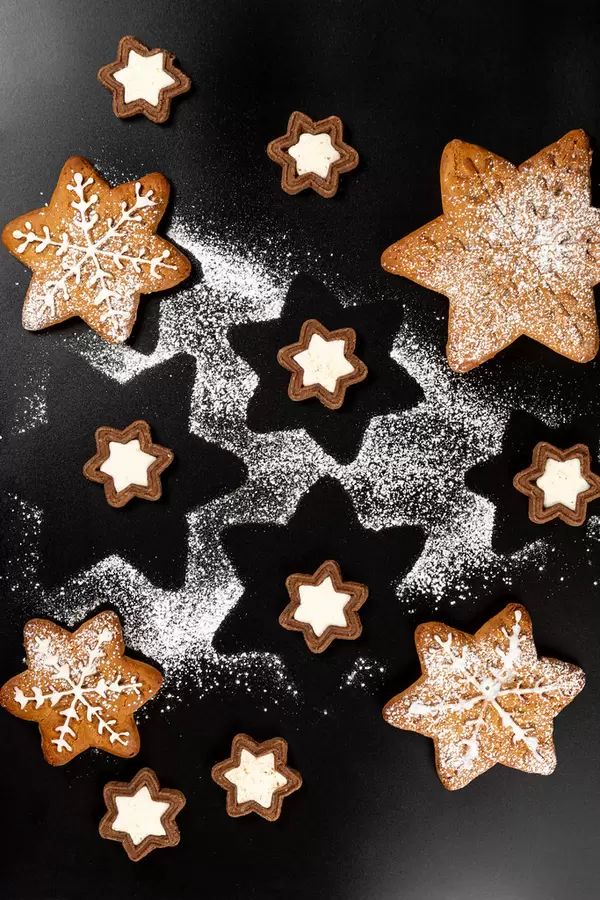Top view of gingerbread snowflakes and cookies stars on dark background