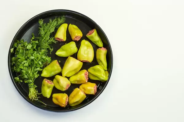 Top view of green bell papers with parsley on white
