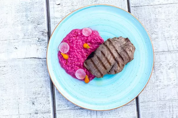 Top view of grilled tuna with beetroot risotto and sweet-lemon foam