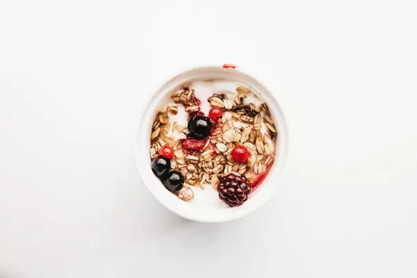 Top view of healthy breakfast- muesli with yogurt and fruits. White background.jpg