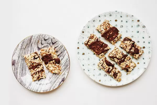 Top view of homemade muesli bars with dates and chocolate. White background.
