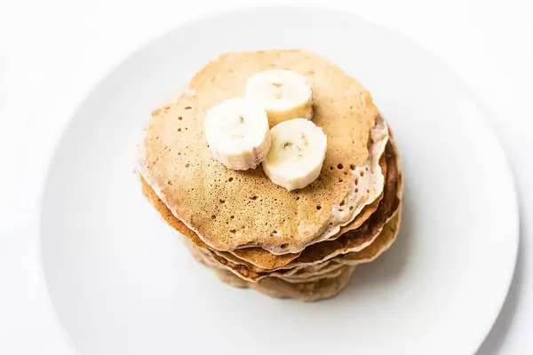 Top view of homemade vegan banana pancakes topped with banana pieces  Flip 2019