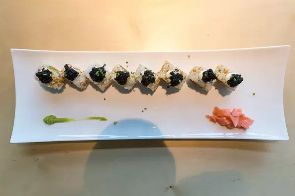 Top view of Japanese Sushi rolls "Lucky No Fish", with avocado, vegan tuna, vegan caviar, spicy sauce, kimchi sesame and spring onions