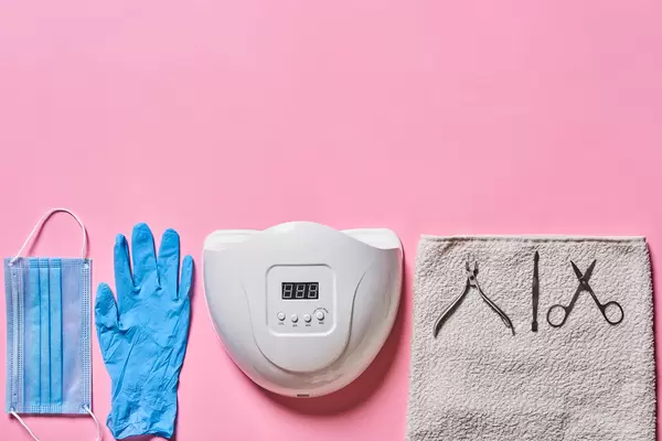 Top view of manicure and pedicure tools on pink background