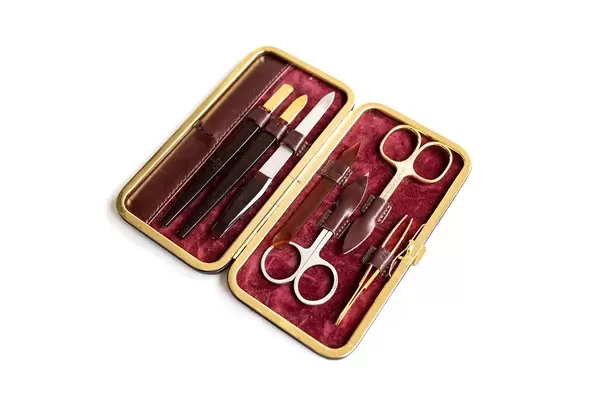 Top view of manicure set with scissors on white background