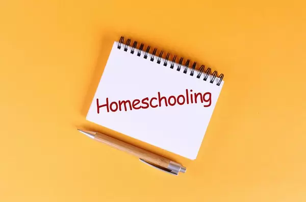 Top view of notebook with Homeschooling text on orange background