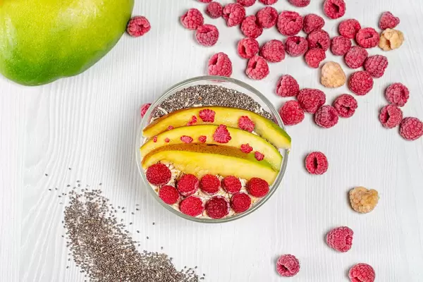 Top view of oatmeal topped with mango, raspberries and Chia seeds (Flip 2019)