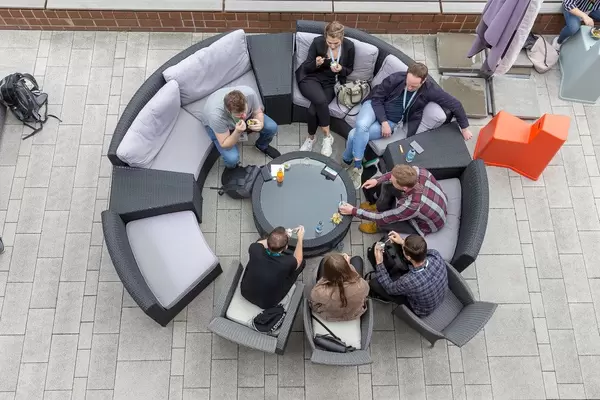 Top view of people on the round garden couch on a terrace of the AXA building, participants of the Barcamp OMWest 2019 in Cologne, Germany