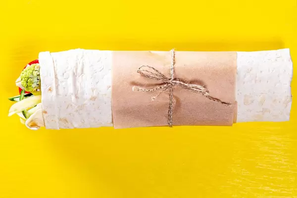 Top view of Shawarma with vegetables on yellow background (Flip 2019)