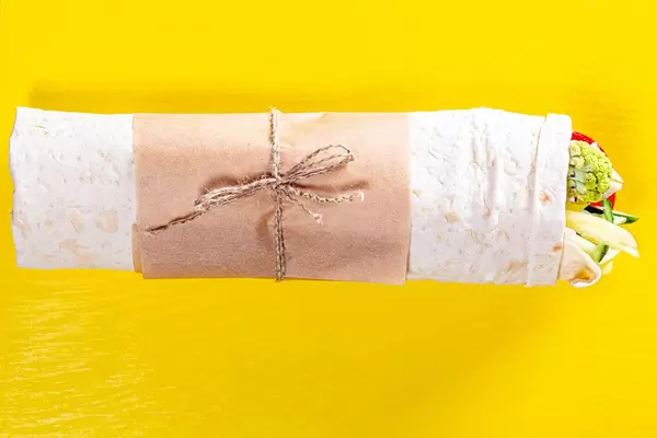 Top view of Shawarma with vegetables on yellow background