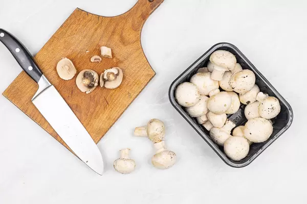 Top view of Sliced Raw Mushrooms on the table with cutting board