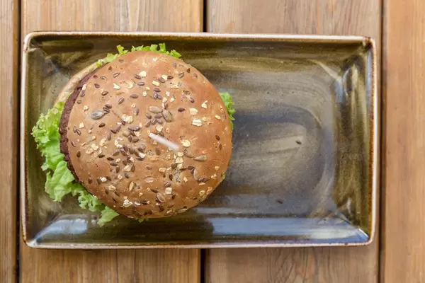 Top view of the vegan healthy burger with wheat proteins & wholegrain bread by Moving Mountains at German Restaurant "Hans im Glück"
